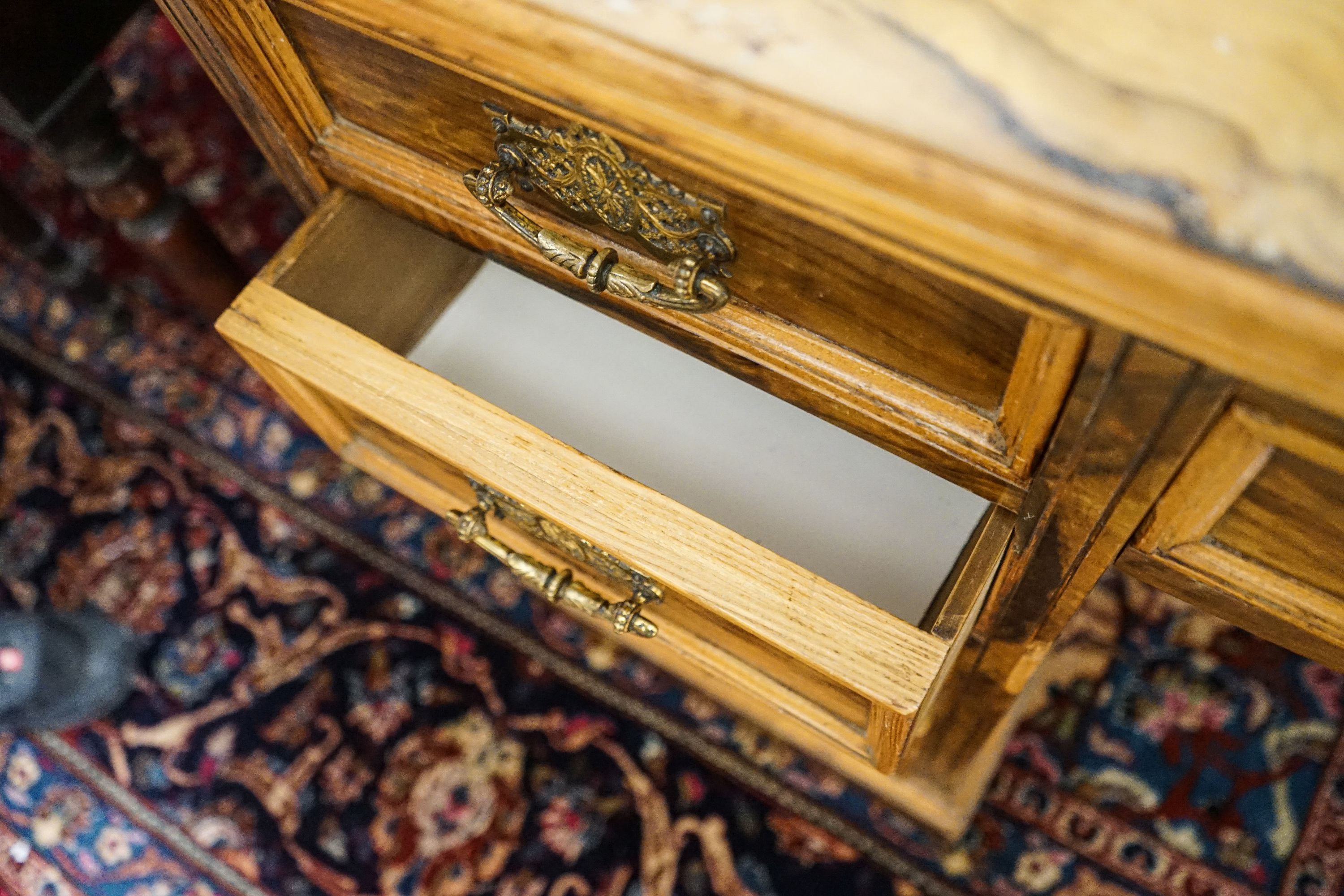 A late Victorian figured walnut twin pedestal desk, fitted with nine drawers with decorative gilt brass handles and plinth base, length 121cm, depth 60cm, height 75cm